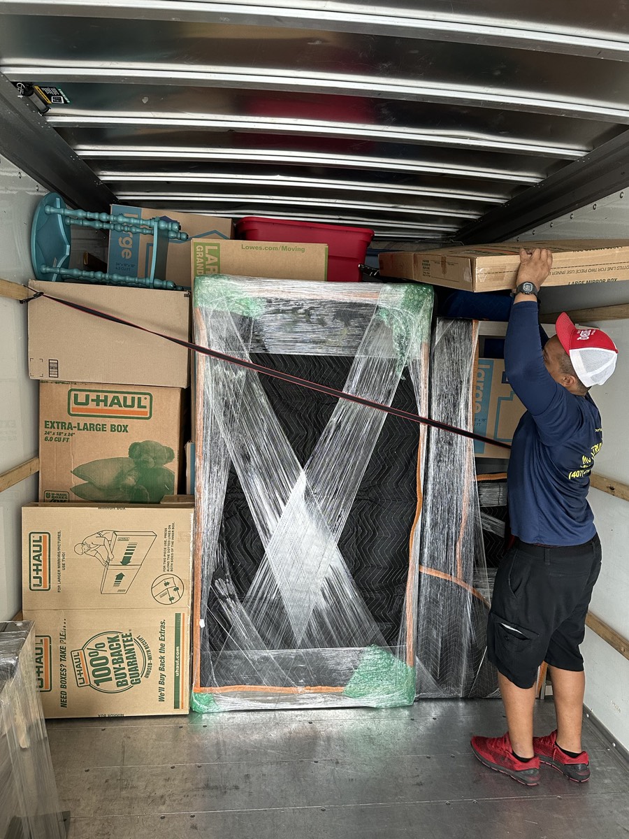 Mover securing and wrapping furniture inside the truck