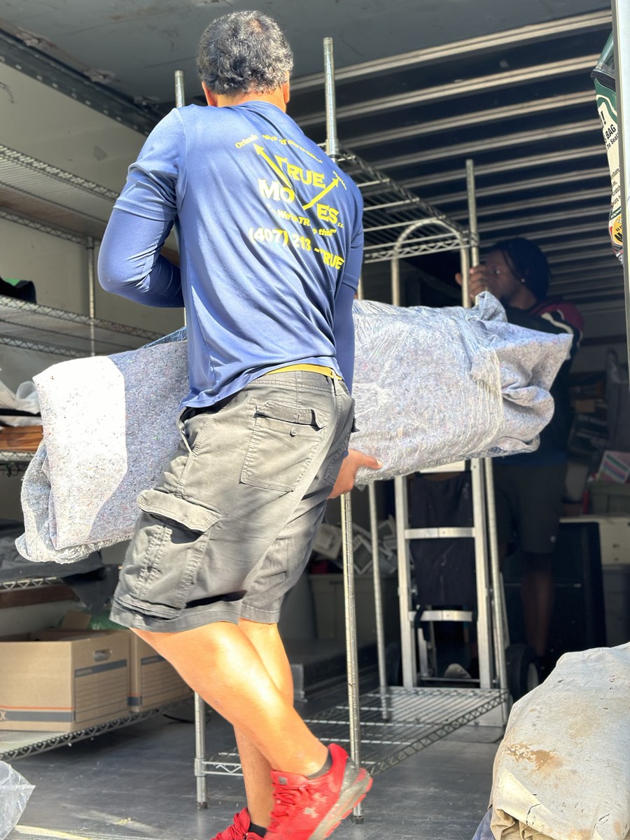 Mover carrying a rolled pad on the shoulder